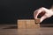 Male hand stacking wooden empty cubes