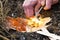 Male hand starts fire with magnesium fire steel, fire striker