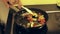 Male hand stirring vegetables in a pan. Fried tomatoes, onions, eggplant.