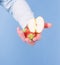 Male hand with strawberries and half of apple blue background. Help yourself. Hand proposes take strawberry and apple