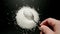 Male hand taking a teaspoon of coarse salt from a pile, top view