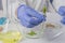 Male hand with a test tube with leaves, on the background of a petri dish with seeds on the table in the laboratory