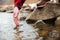 Male hand testing water in river