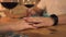 Male hand touching female hand while romantic date in evening restaurant. Woman touching hand girlfriend on table at