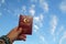 Male hand with turkish passport blue sky and shining sun