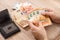 Male hands arrange Euro banknotes on the table. A black leather wallet lies on the table.