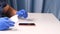 Male hands in blue gloves replaces a broken tempered glass screen protector for a smartphone. A man prepares a