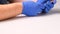 Male hands in blue gloves replaces a broken tempered glass screen protector for a smartphone. A man prepares a