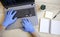 Male hands in blue protective gloves working on modern laptop. Specialist doctor in blue latex gloves. Medical mask is on the desk