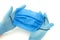 Male hands with blue rubber gloves hold medical mask