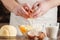 Male hands breaking eggs into a bowl; closeup