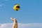 Male hands catching valleyball ball on a background of a blue sky