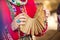 Male hands of a caucasian man, dressed in traditional attire, hold a wooden rattle dance instrument