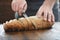 Male hands chopped fresh bread wooden table