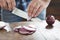 Male hands chopped fresh red onion wooden table close up