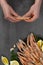 Male hands cleaning boiled langoustines on black plate  on gray concrete table. Served with lemon and spicy