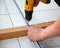 Male hands of  construction worker tighten and fix  screws and self-tapping screw  with  electric cordless screwdriver for home