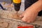 Male hands of  construction worker tighten and fix  screws and self-tapping screw  with  electric cordless screwdriver for home