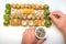 Male hands cook sprinkled rolls in a set of sesame seeds