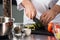 Male hands cut food at kitchen. Closeup chef hands cut cucumber.