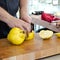 Male hands cut a large yellow quince on a wooden cutting board