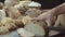 Male hands cutting the fresh baked Dutch bread on the wooden table