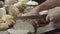 Male hands cutting the fresh baked Dutch bread on the wooden table