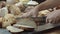 Male hands cutting the fresh baked Dutch bread on the wooden table