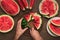 Male hands cutting red ripe watermelon with knife into slices
