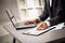 Male hands doing paperwork with pen and laptop.