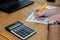 Male hands fill out tax forms 1040 on the background of a calculator and laptop. Office concept.