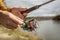 Male hands of a fisherman are holding a spinning closeup. Concept of fishing in the autumn forest