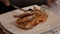 Male hands with fork and knife cut cake on a white plate