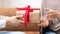 Male Hands Giving Gift Box To Muslim Wife Indoors, Closeup