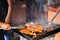 Male hands grilling chili meat on charcoal grill