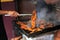 Male hands grilling chili meat on charcoal grill