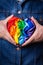 Male hands with heart shaped rainbow lgbtq flag, pride month