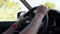 Male hands hold car steering wheel while driving by off road