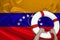 Male hands hold on a white life buoy against the background of the silk national flag of the country of Venezuela, the concept of