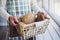 Male hands holding basket with freshly baked bread of different kinds with bran in daylight