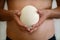 Male hands holding of big ostrich egg on white background, size comparison, close up. Organic fresh egg. Healthy food. Ostrich egg