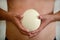 Male hands holding of big ostrich egg on white background, size comparison, close up. Organic fresh egg. Healthy food. Ostrich egg