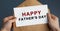 Male hands holding craft envelope with text HAPPY FATHER`S DAY