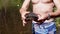 Male Hands Holding a European Pond Turtle on a Blurred Background of a River