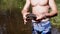 Male Hands Holding a European Pond Turtle on a Blurred Background of a River