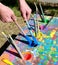 Male hands holding loading brushes with blue paint from ouache p