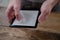 Male hands holding modern black e-book reader, digital book, tablet computer device for displaying text electronically, electronic