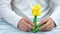 Male hands holding yellow origami tulip.