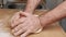 Male hands kneading dough, baking preparation closeup. Pastry Man kneads making yeast dough for pizza, burger, buns