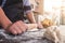 Male hands kneading dough sprinkled with flour table